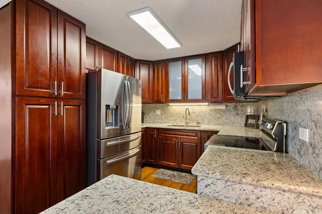 a kitchen with granite countertop stainless steel appliances wooden cabinets a sink and a granite counter tops