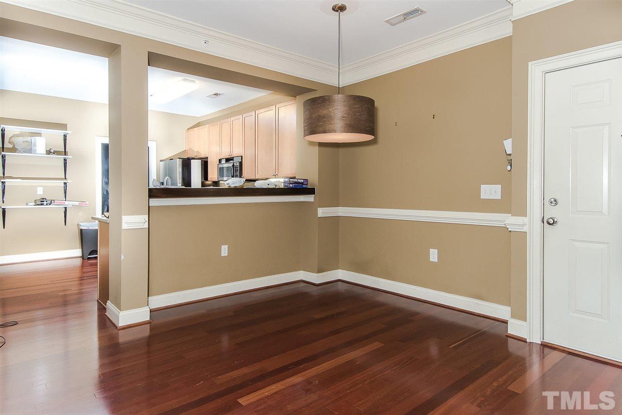 3811 Lunceston Way, Unit 301 Raleigh, NC 27613 - Photo 3 of 8 a view of a kitchen with wooden floor and a ceiling fan
