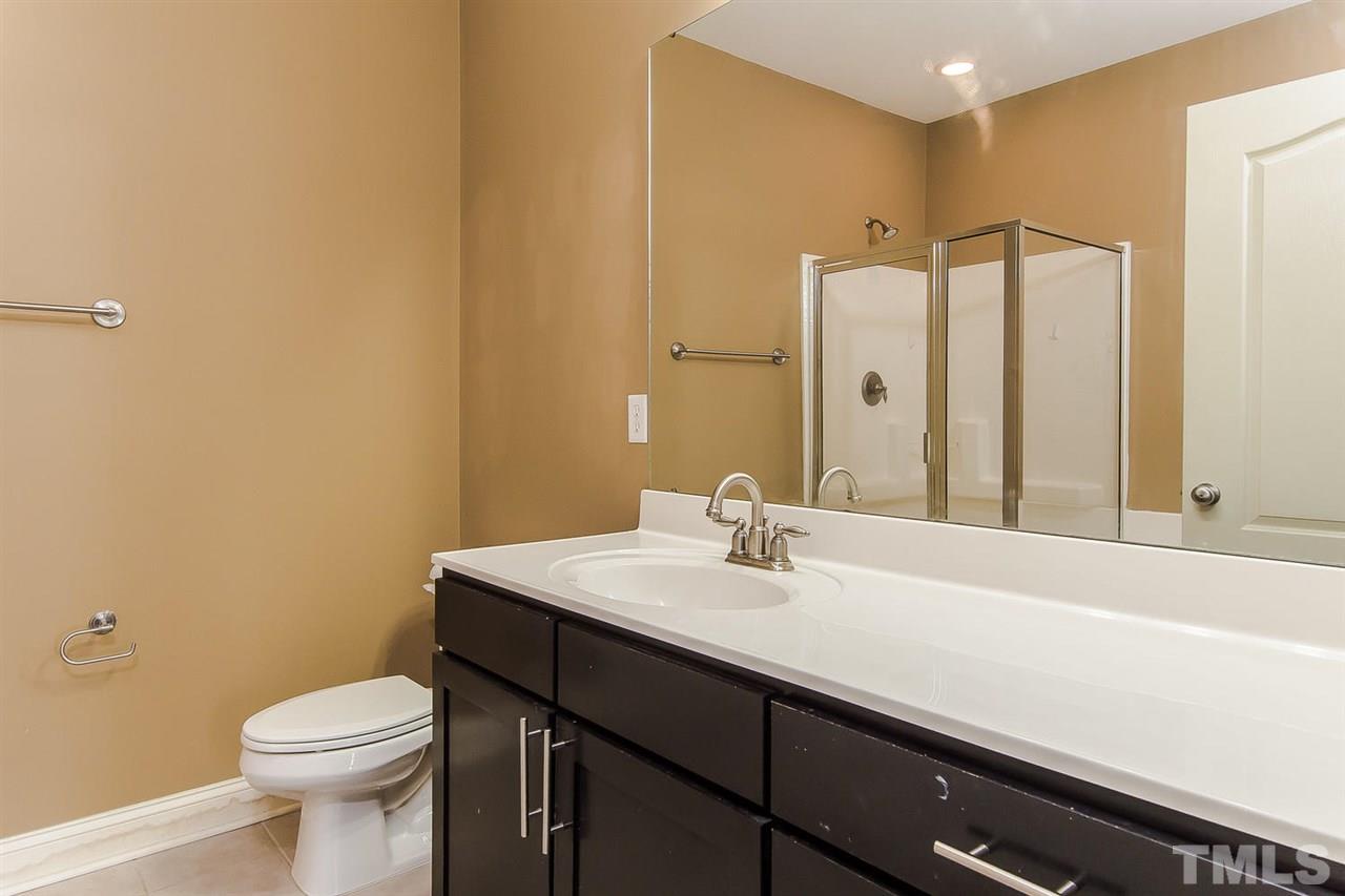 3811 Lunceston Way, Unit 301 Raleigh, NC 27613 - Photo 5 of 8 a bathroom with a sink a toilet and mirror