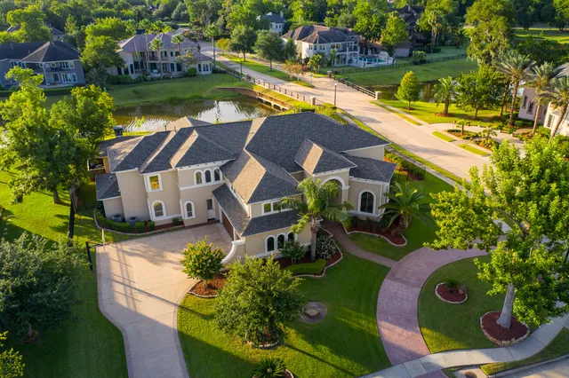 an aerial view of a house with a garden and lake view