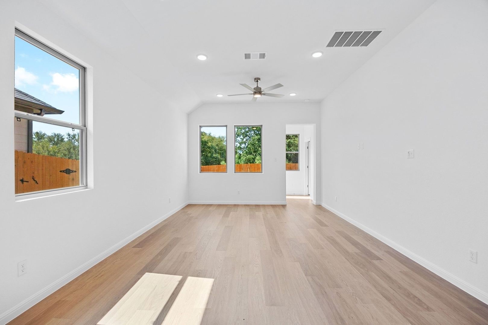 310 Bendecido Loop Elgin, TX 78621 - Photo 4 of 40 wooden floor in an empty room with a window
