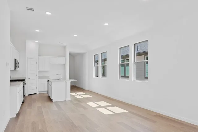 a view of an empty room with a kitchen