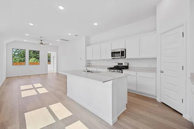a kitchen with cabinets appliances a sink and a counter top space