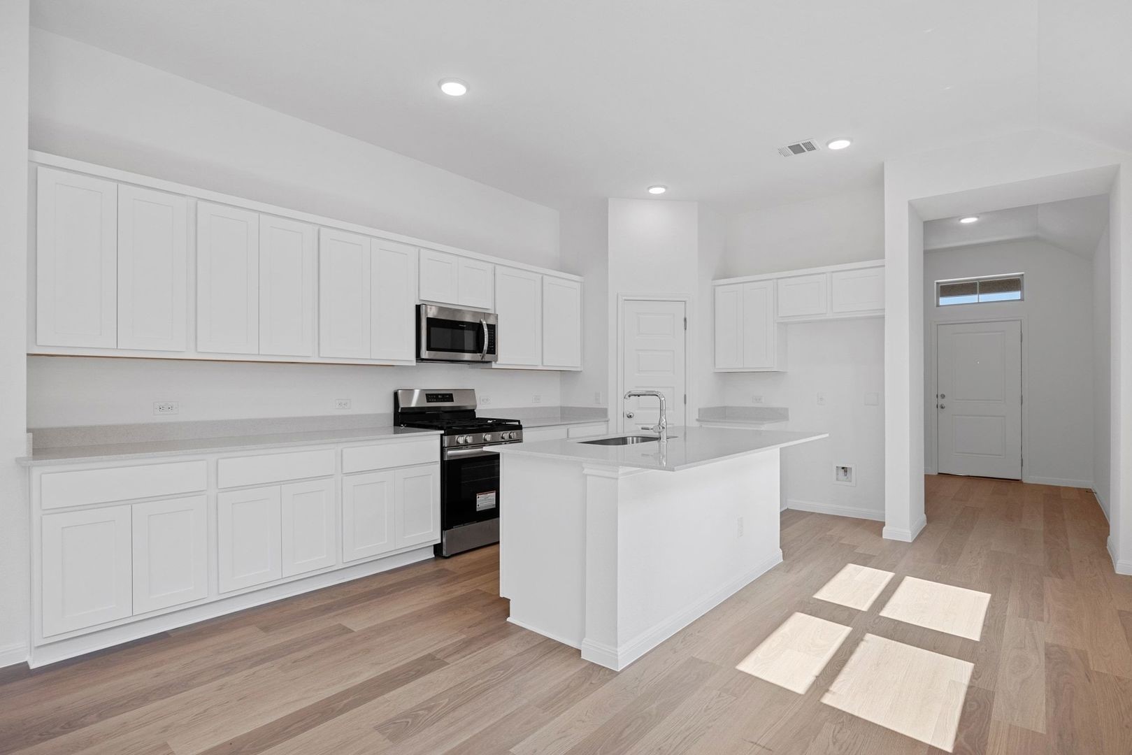 310 Bendecido Loop Elgin, TX 78621 - Photo 9 of 40 a kitchen with white cabinets and appliances