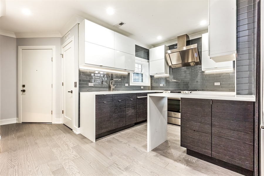2141 West Fletcher Street, Unit 3F Chicago, IL 60618 - Photo 3 of 11 a kitchen with stainless steel appliances granite countertop a stove a sink and a refrigerator