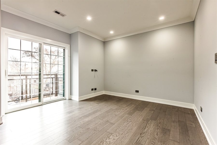 2141 West Fletcher Street, Unit 3F Chicago, IL 60618 - Photo 6 of 11 a view of an empty room with wooden floor and a window