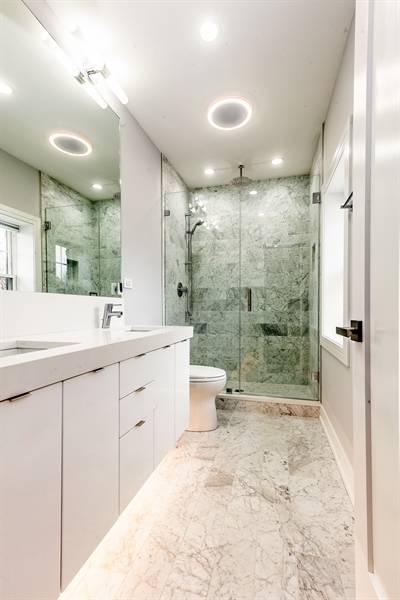 2141 West Fletcher Street, Unit 3F Chicago, IL 60618 - Photo 9 of 11 a bathroom with a double vanity sink toilet mirror and shower