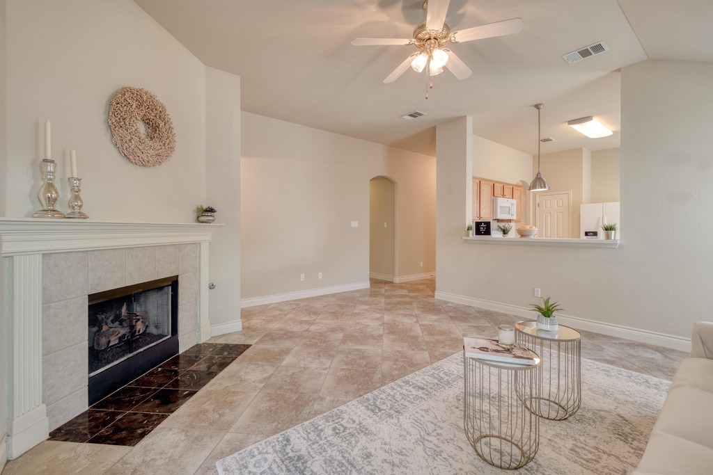 1303 Ridgewood Drive Leander, TX 78641 - Photo 11 of 28 a living room with furniture a clock and a fireplace