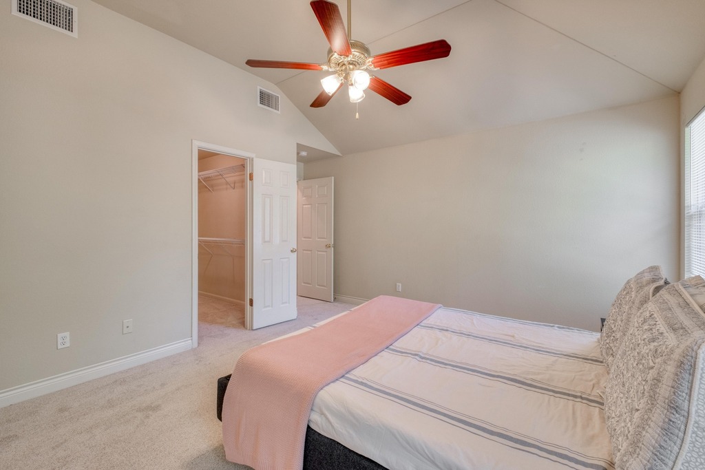 1303 Ridgewood Drive Leander, TX 78641 - Photo 13 of 28 a bedroom with a bed and a chandelier