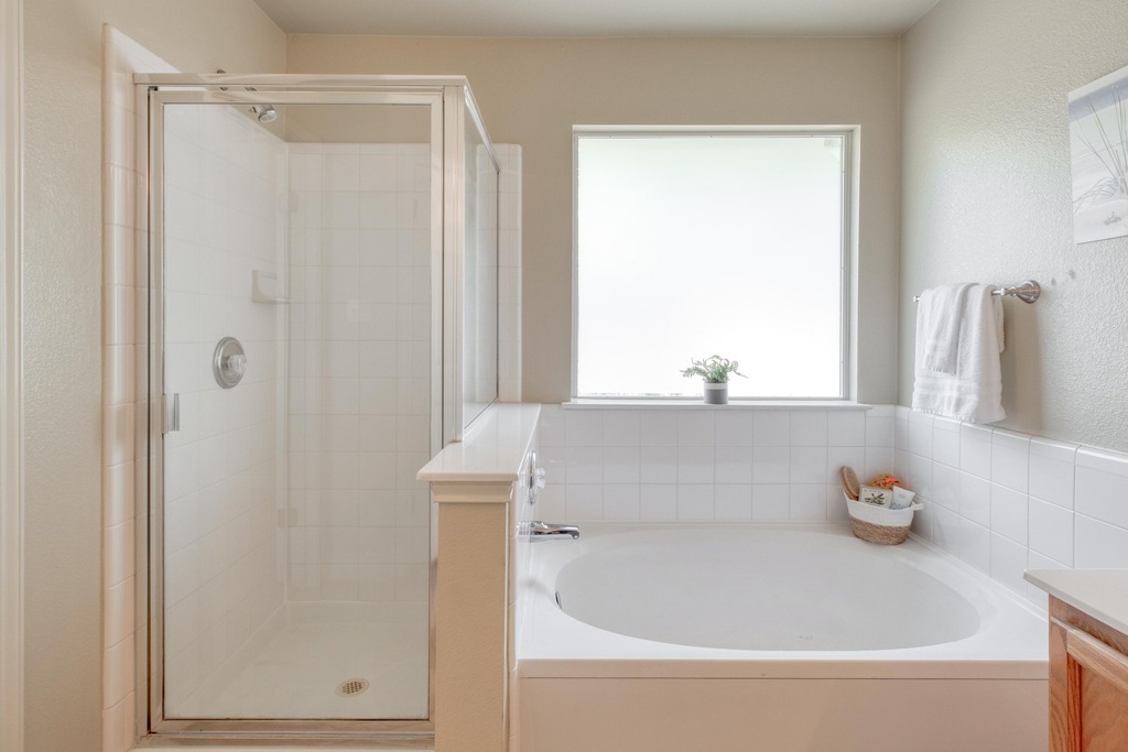 1303 Ridgewood Drive Leander, TX 78641 - Photo 16 of 28 a bathroom with a tub and a shower