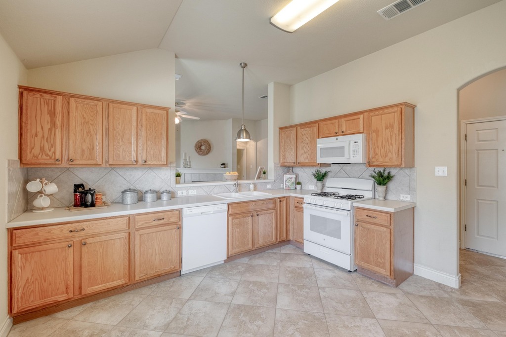 1303 Ridgewood Drive Leander, TX 78641 - Photo 5 of 28 a kitchen with white cabinets and white appliances