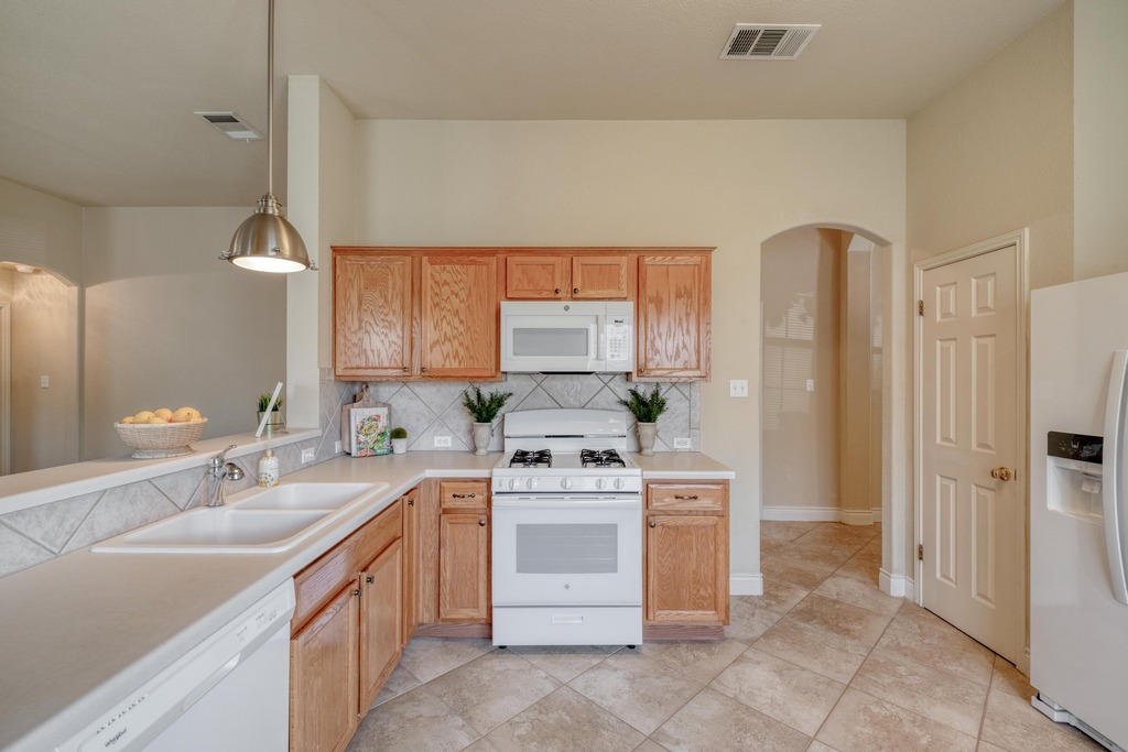 1303 Ridgewood Drive Leander, TX 78641 - Photo 6 of 28 a kitchen with a stove sink and refrigerator