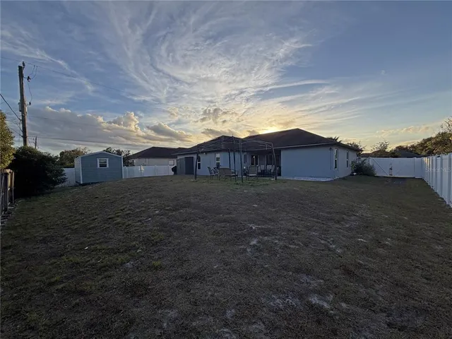 a view of a house with backyard and trees