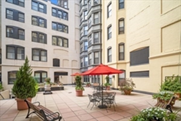4 Charlesgate East, Unit 602 Boston, MA 02215 - Photo 20 of 24 a view of a patio with a table and chairs under an umbrella
