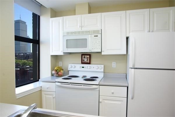 4 Charlesgate East, Unit 602 Boston, MA 02215 - Photo 6 of 24 a kitchen with a refrigerator a stove a microwave and cabinets