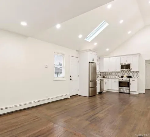 a view of kitchen with refrigerator stove and wooden cabinets