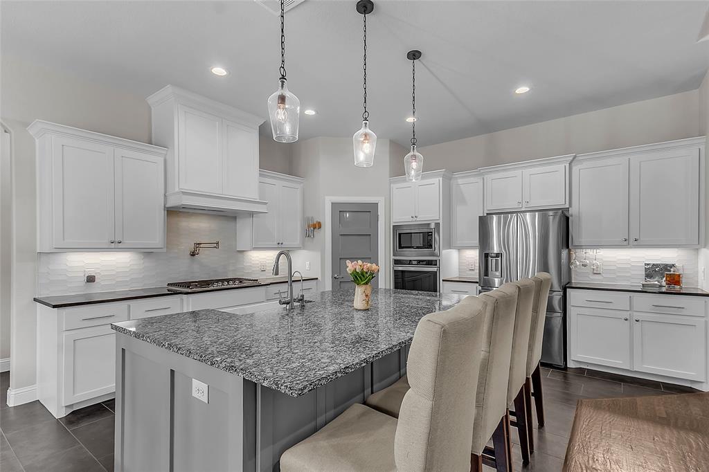 1014 Rennard Street Caddo Mills, TX 75135 - Photo 13 of 39 Kitchen featuring a large island with granite countertop, shaker-style cabinetry, stainless steel appliances, a gas range with pot filler, and recessed lighting