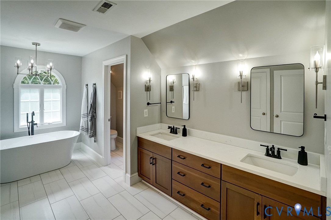 1295 Hermitage Road Manakin-Sabot, VA 23103 - Photo 43 of 55 a spacious bathroom with a granite countertop sink mirror and bathtub