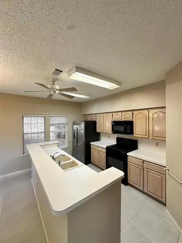a kitchen that has a sink and a stove top oven
