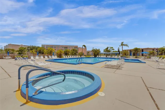 a view of swimming pool with outdoor seating and shower in the back