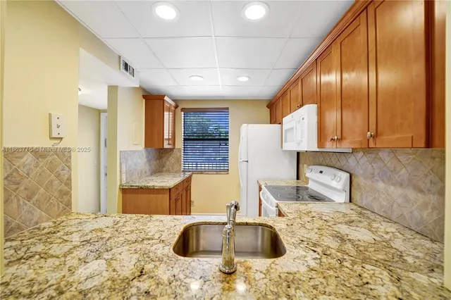 a kitchen with stainless steel appliances kitchen island granite countertop a sink and cabinets