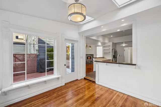 a view of a kitchen with wooden floor and a window