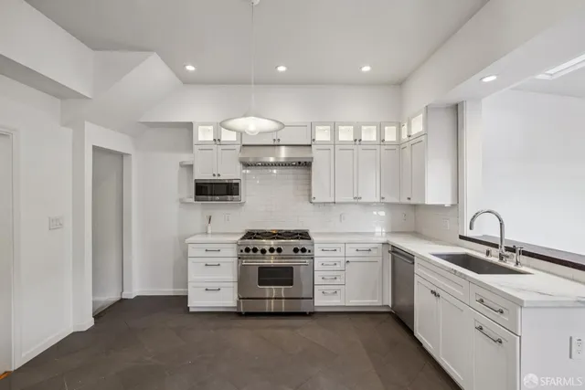 a kitchen with stainless steel appliances a sink stove and cabinets