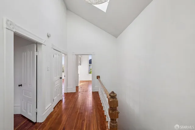 a view of a hallway with wooden floor and staircase
