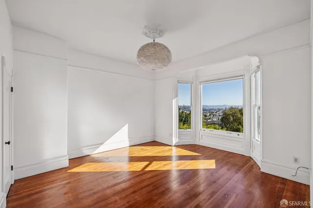 a room with wooden floor and a window