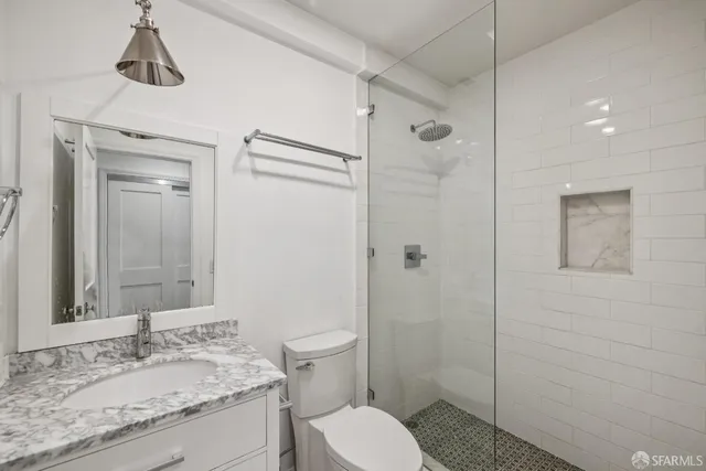 a bathroom with a granite countertop sink toilet and shower