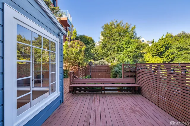 a backyard of a house with wooden floor and outdoor seating