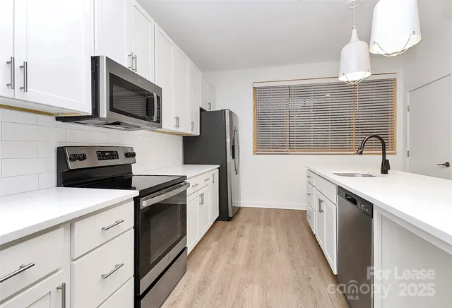 a kitchen with a sink a stove and microwave
