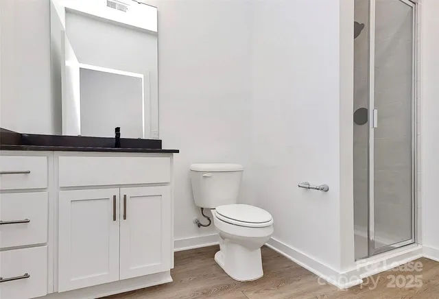 a bathroom with a granite countertop sink and a toilet