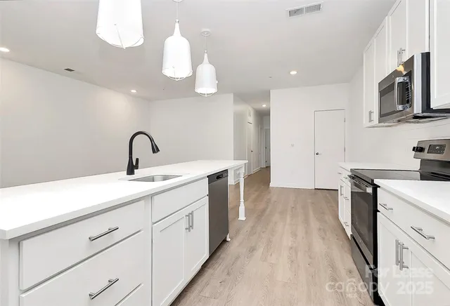 a kitchen with a sink dishwasher a stove and a microwave oven with cabinets