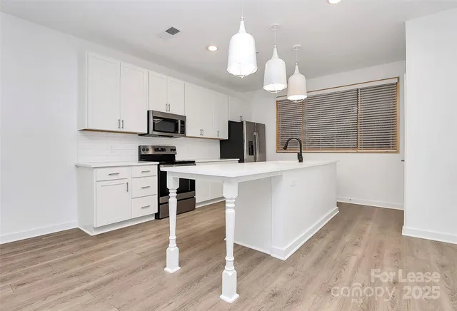 a kitchen with a sink a microwave and cabinets