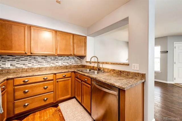 a kitchen with granite countertop cabinets sink and wooden floor