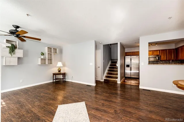 a view of a livingroom with wooden floor and a ceiling fan