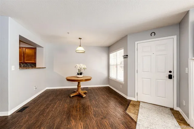 a view of a livingroom with wooden floor a cabinet and windows