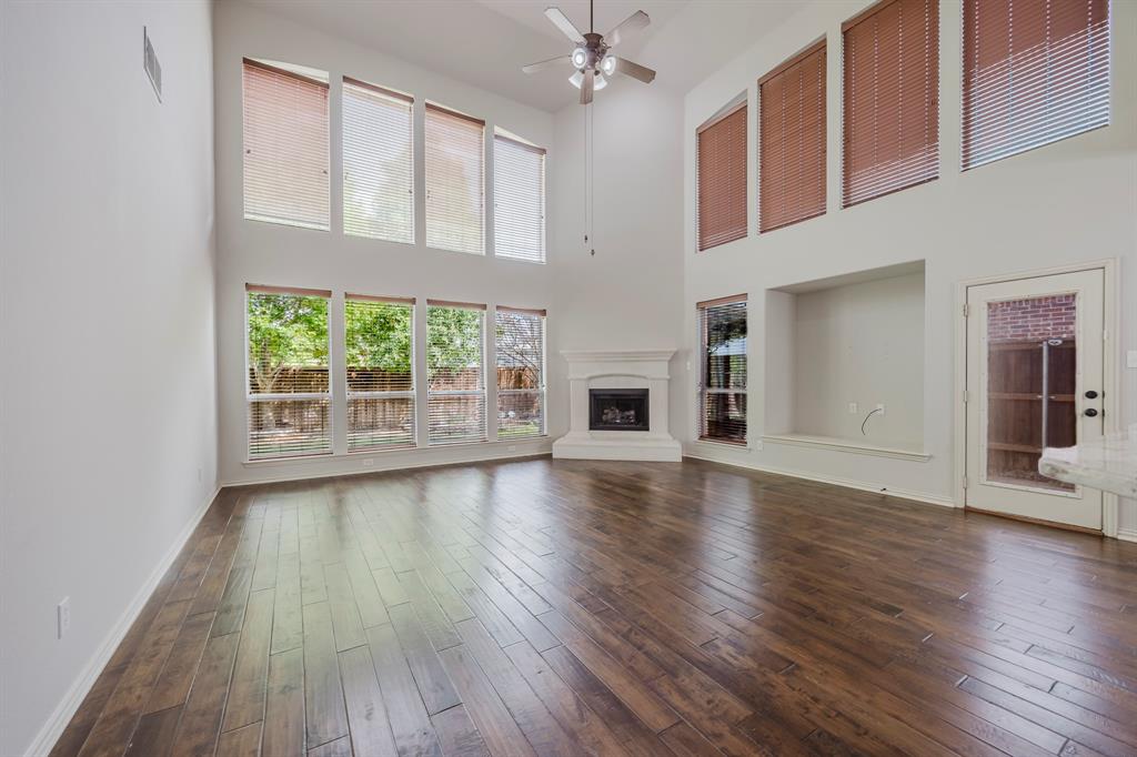 362 Spring Meadow Drive Fairview, TX 75069 - Photo 16 of 38 a view of a livingroom with wooden floor and a kitchen