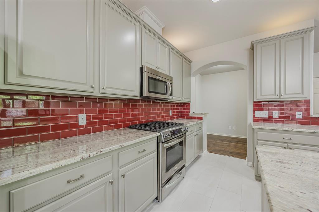 362 Spring Meadow Drive Fairview, TX 75069 - Photo 9 of 38 a kitchen with granite countertop cabinets stainless steel appliances and sink