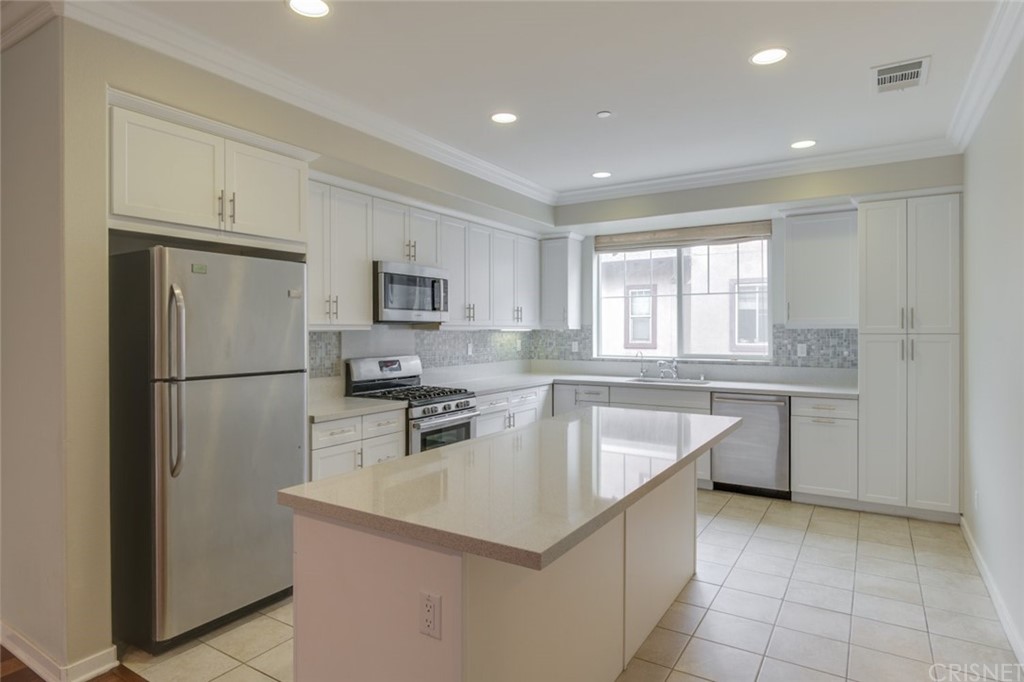 713 South Azusa Avenue, Unit D Azusa, CA 91702 - Photo 18 of 44 a kitchen with granite countertop a refrigerator a sink a stove a microwave a counter top and cabinets