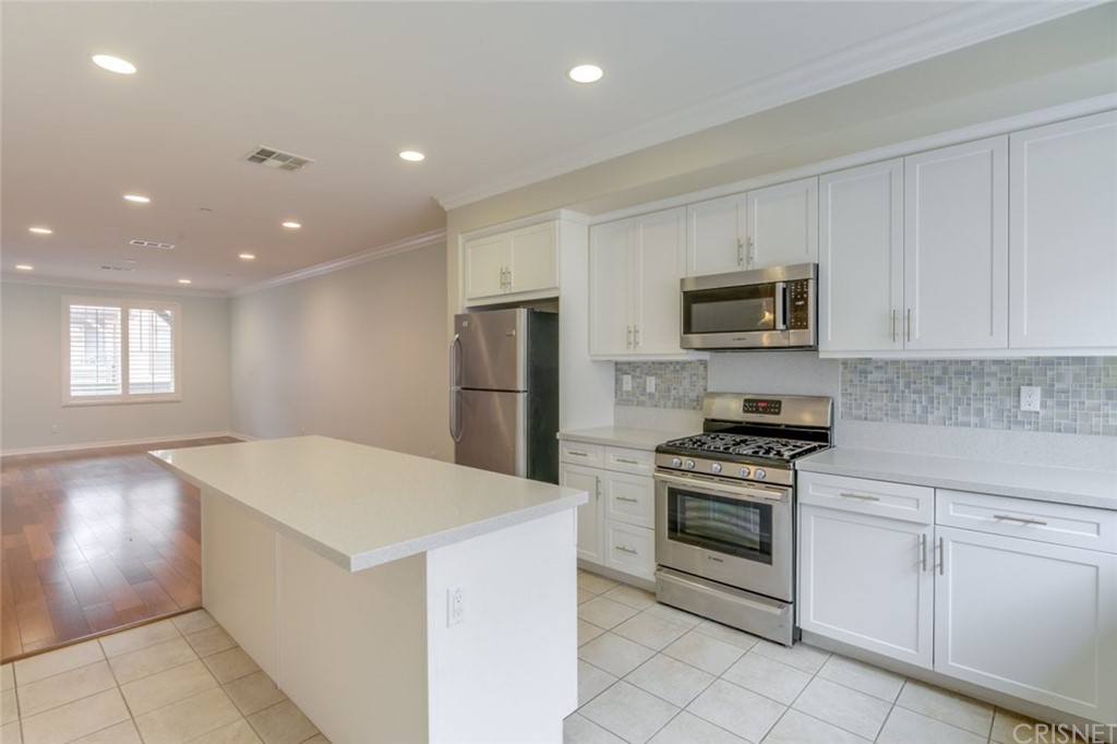 713 South Azusa Avenue, Unit D Azusa, CA 91702 - Photo 19 of 44 a kitchen that has a sink a stove and white cabinets