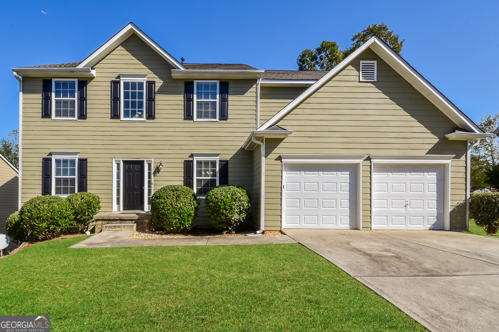 a front view of a house with a yard and garage