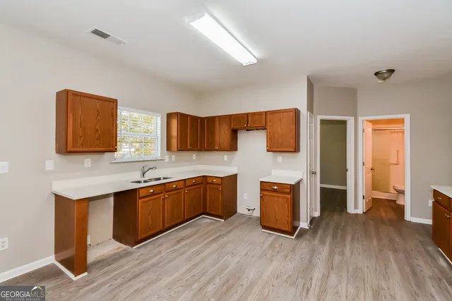 a kitchen with stainless steel appliances kitchen island granite countertop a sink and wooden floor