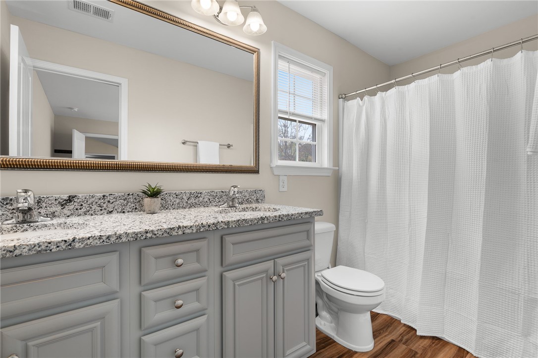 114 Sunny Pt Loop Central, SC 29630 - Photo 13 of 25 This bathroom features a double vanity with granite counters and a shower with a privacy curtain.
