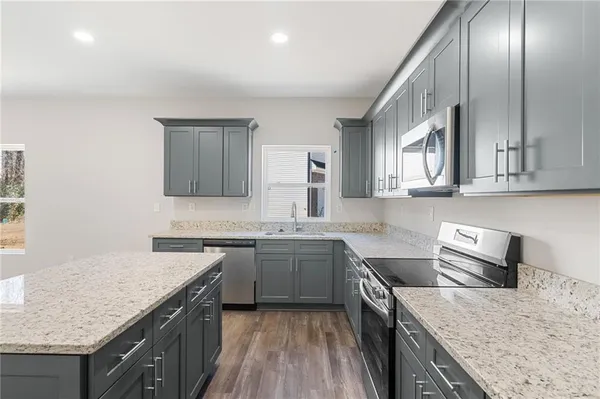 a kitchen with a stove sink and cabinets