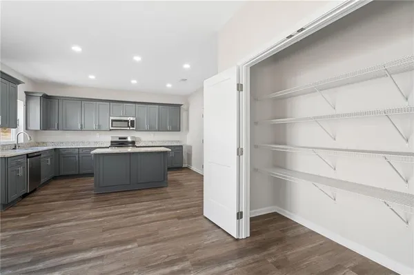 a kitchen with stainless steel appliances a sink cabinets and wooden floor