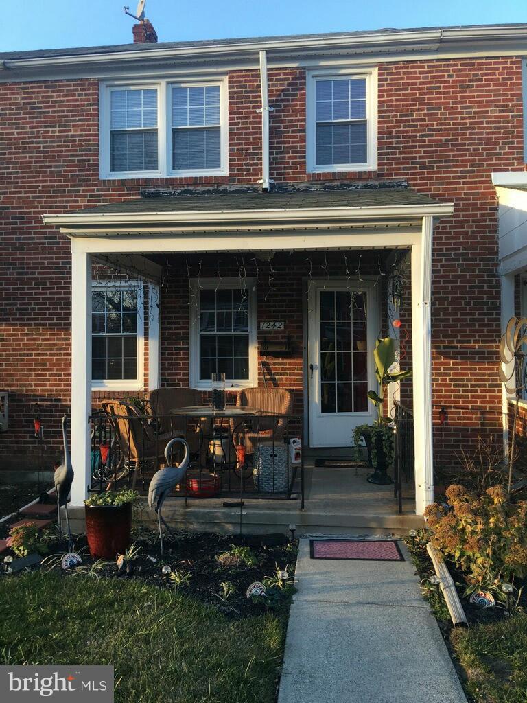 1242 Cedarcroft Road Baltimore, MD 21239 - Photo 1 of 22 a front view of a house with outdoor seating and a pathway