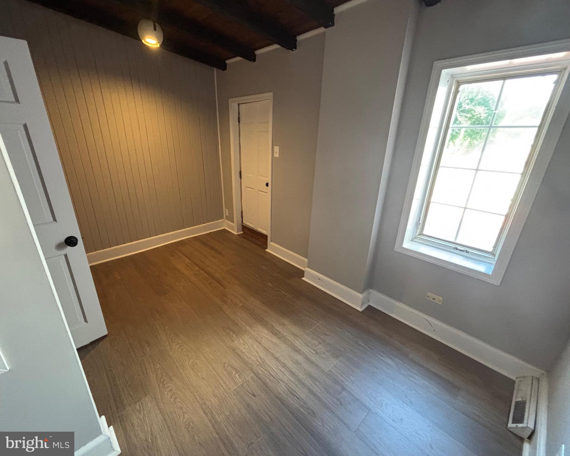 903 Lovering Avenue Wilmington, DE 19806 - Photo 11 of 16 an empty room with wooden floor and windows