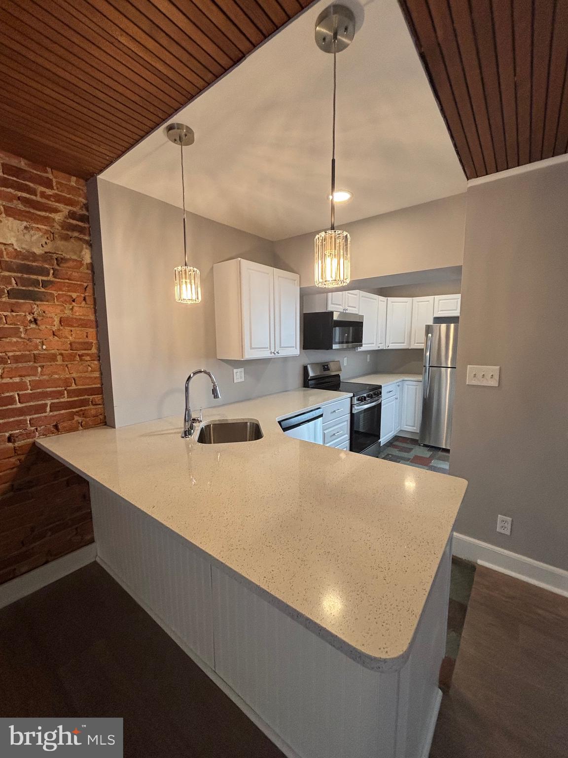 903 Lovering Avenue Wilmington, DE 19806 - Photo 3 of 16 a large kitchen with stainless steel appliances a large counter top a stove and a refrigerator